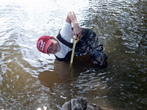 Jack Carter pulls the thermometer off of the bottom of the Huron River, near Flat Rock Dam.
