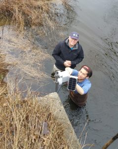 HRWC volunteer Larry and University of Michigan researcher Brandon installing stream sensor equipment.