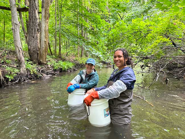 Photo of two people from HRWC staff in a creek