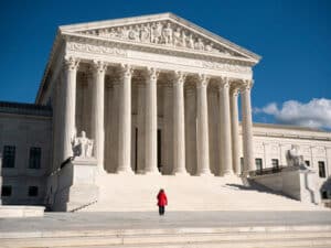 Woman in a red coat in front of the U.S. Supreme Court