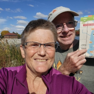 two people smiling with trail map