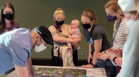 People standing around a table looking at a map