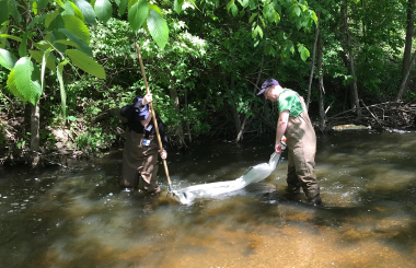 staff sampling river water to check for microplastics